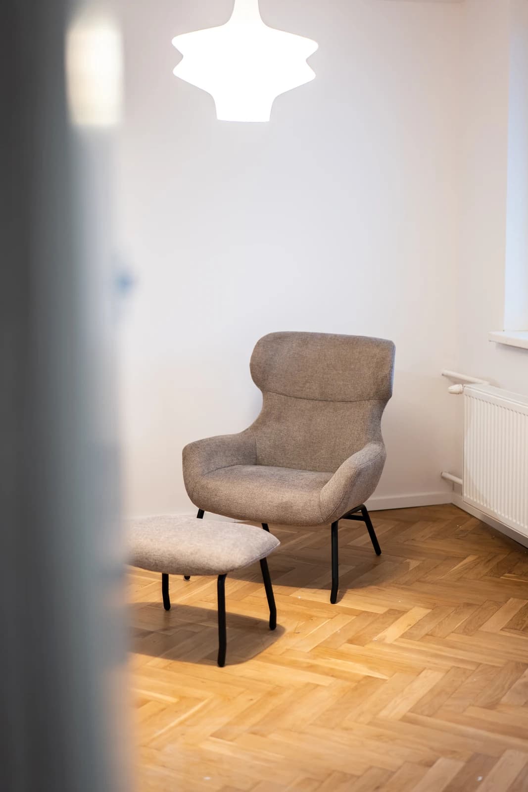 Štýlová tmavá kuchyňa s moderným osvetlením, zlatými akcentmi a elegantným jedálenským stolom.