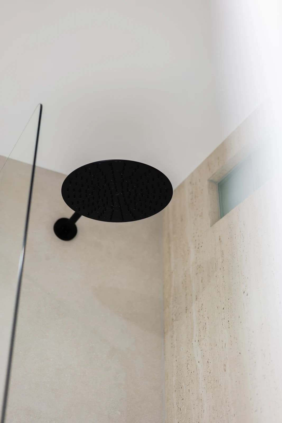 Štýlová tmavá kuchyňa s moderným osvetlením, zlatými akcentmi a elegantným jedálenským stolom.