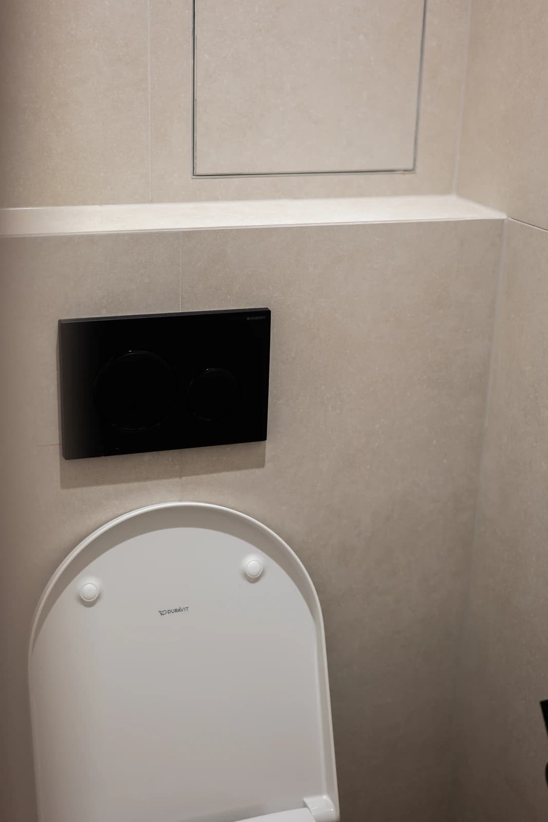 Štýlová tmavá kuchyňa s moderným osvetlením, zlatými akcentmi a elegantným jedálenským stolom.