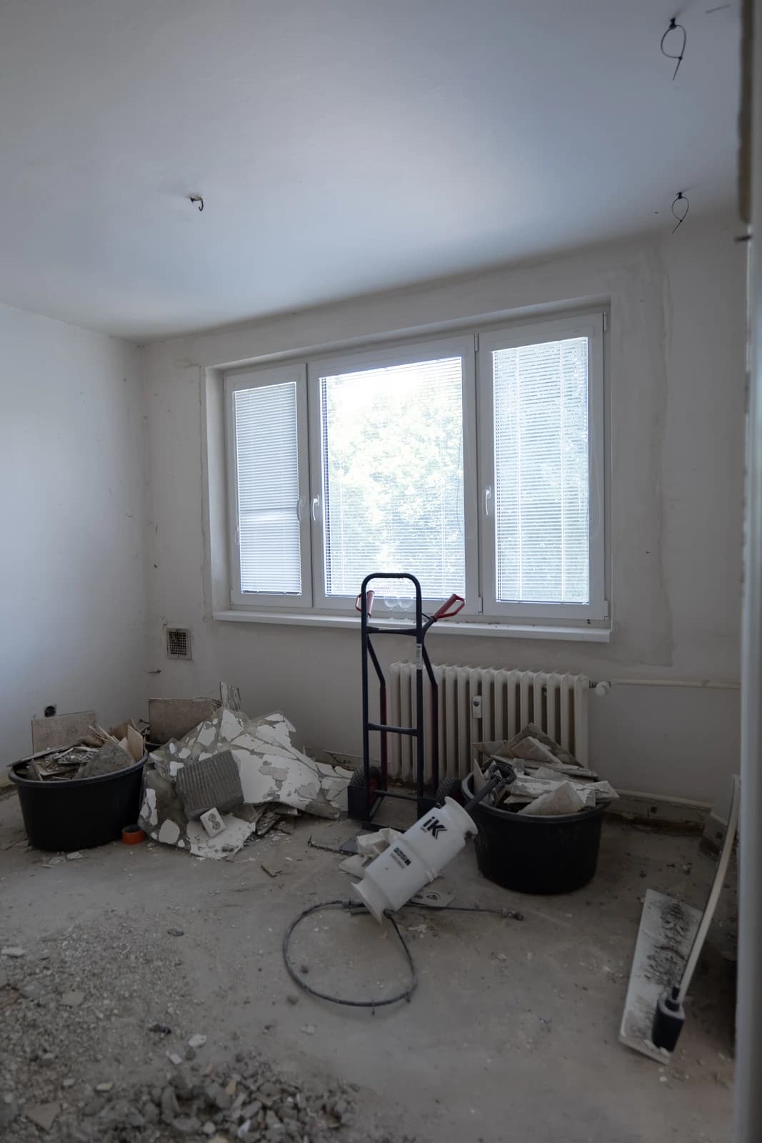 Štýlová tmavá kuchyňa s moderným osvetlením, zlatými akcentmi a elegantným jedálenským stolom.