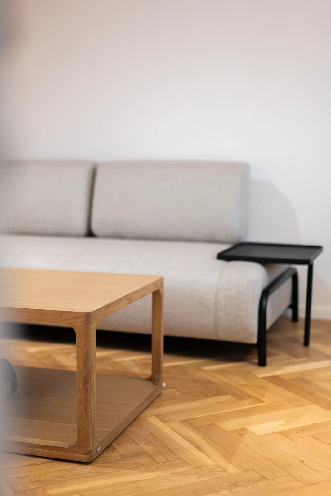 Štýlová tmavá kuchyňa s moderným osvetlením, zlatými akcentmi a elegantným jedálenským stolom.