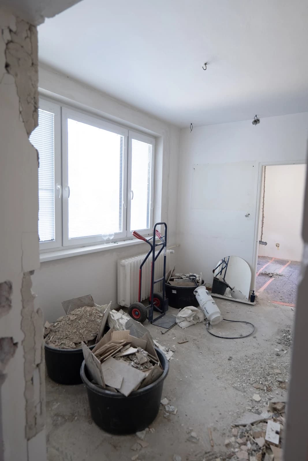 Štýlová tmavá kuchyňa s moderným osvetlením, zlatými akcentmi a elegantným jedálenským stolom.