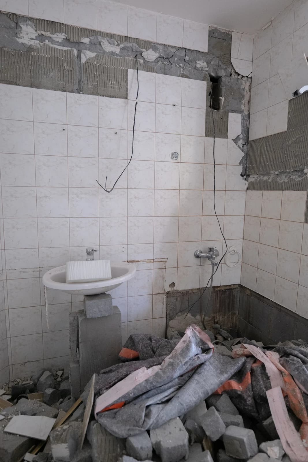 Štýlová tmavá kuchyňa s moderným osvetlením, zlatými akcentmi a elegantným jedálenským stolom.