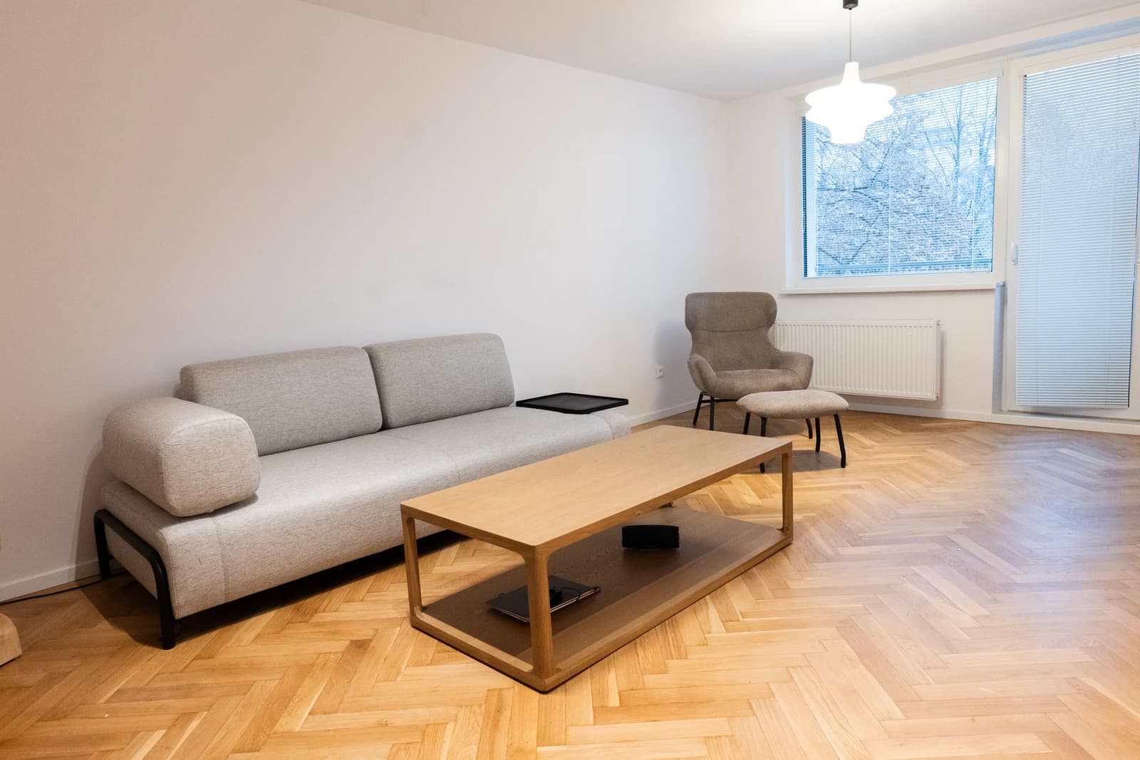 Štýlová tmavá kuchyňa s moderným osvetlením, zlatými akcentmi a elegantným jedálenským stolom.