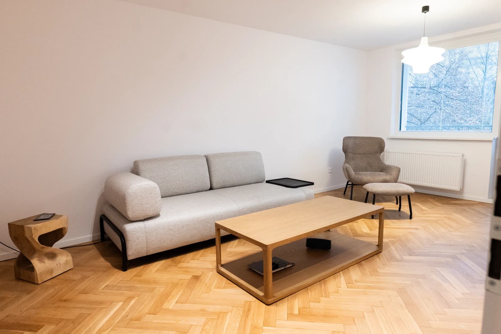 Štýlová tmavá kuchyňa s moderným osvetlením, zlatými akcentmi a elegantným jedálenským stolom.